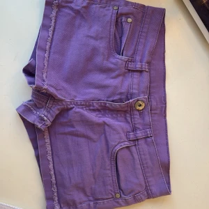 Lila shorts med fransar - Snygga lila shorts med fransiga kanter och klassisk femficksdesign. Perfekta för en avslappnad sommarlook. De har en knapp och dragkedja framtill. Midjemått 36, längd 24 Skriv om du har några frågor❤️