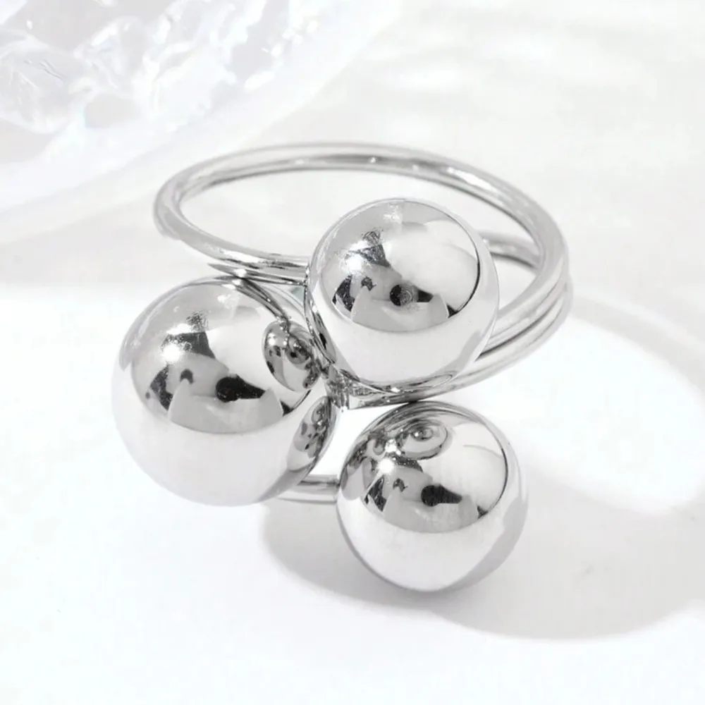 Trendig silverfärgad ring med tre stora, blanka kulor som ger ett unikt och modernt utseende. Perfekt för att ge en stilren touch till din outfit.. Asusteet.