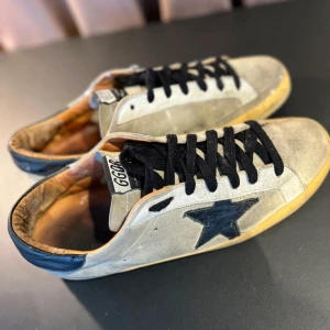 Golden Goose - Tja! Nu säljer vi dessa feta Golden goose sneakers i storleken 43. Skicket på dessa är 6/10 eftersom att sulan på vänster sko är lite lös men det går att fixa jätte lätt med lite lim 👍. Priset kan diskuteras vid snabb affär.