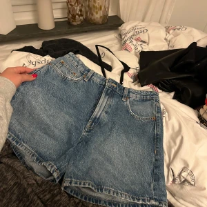 Blå jeansshorts - Säljer ett par klassiska blå jeansshorts med femficksdesign och knappgylf. Från Zara i 36