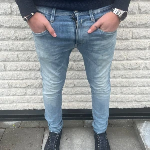 Replay anbass  - Snygga blå jeans från Replay med en slum passform. Dessa jeans har en dragkedja och är tillverkade i Hyperflex-material för extra komfort och stretch. Perfekta för en stilren look. Modellen är 185 70kg