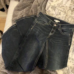 Mörkblå jeans med broderad bakficka - Snygga mörkblå jeans med en unik broderad design på bakfickan. Jätte bra för sommaren och är enkla men med fina detaljer. Endast andvänt 2-3 gånger och är helt nya! Storlek 152