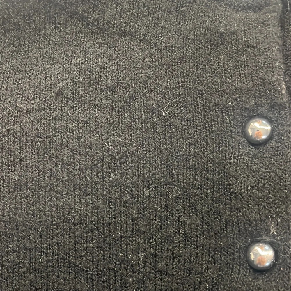 Säljer en stilren svart kofta från H&M i storlek XS. Koftan har korta ärmar och knappar framtill, perfekt för en enkel och elegant look. Materialet är mjukt och bekvämt, vilket gör den idealisk för både vardag och speciella tillfällen.. Neuletakit & Villapaidat.