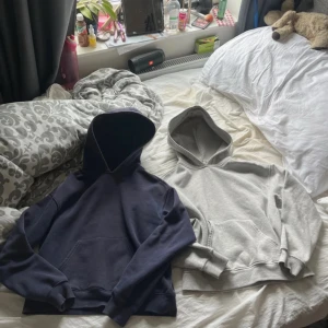 Blå och grå hoodies från Gina  - Två bekväma hoodies i blått och grått. Båda har en klassisk design med huva och magficka. Perfekta för en avslappnad stil. Grå:XS blå:XXS