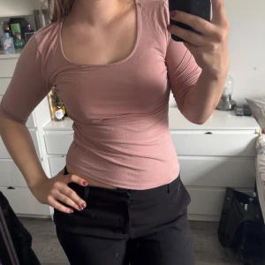 Rosa topp med snörning - rosa topp med trekvartsärm och snygg snörning i ryggen. Toppen har en tight passform och är gjord i ett mjukt material. (Katt och kanin finns i hemmet) 