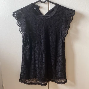 Svart blus topp från Pieces - Säljer en svart blus topp i storlek S från Pieces med spetsdetaljer och volang ärmar. Använd bara vid fina tillfällen så inga defekter eller fläckar💗