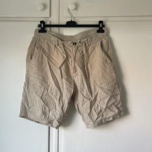 Beiga Linneshorts från Lindbergh - Säljer ett par beiga shorts från Lindbergh i storlek M, som tyvärr är för små för mig, de är perfekta för sommaren. Skriv vid frågor eller funderingar!