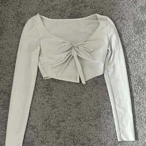 Vit långärmad croppad topp xs - Säljer en stilren vit långärmad topp. Toppen är croppad och har en elegant design som passar perfekt till olika tillfällen. Från SHEIN i storlek xs