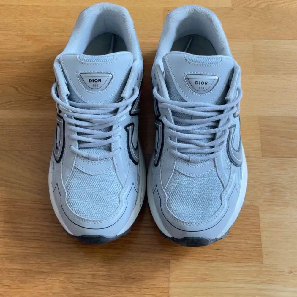  Helt nya Snygga Dior b30 sneakers från Dior med reflekterande detaljer och snörning.  Använd en gång. Det finns box men den är lite sliten.Skorna har en modern design med en bekväm sula och är perfekta för en stilren look. Storlek 43 men passar även 44 bra pris går att diskuteras vid snabb affär.. . Kengät.