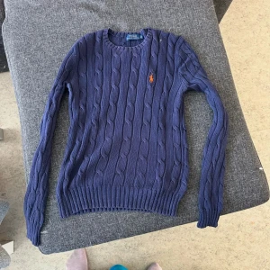 Mörkblå kabelstickad tröja från Ralph Lauren - Säljer en marinblå stickad tröja från Ralph Lauren. Inte mycket använd så i nyskick. Fler bilder kan tas vid intresse. Nypris runt 2000kr. Priset kan diskuteras vid snabb & smidig affär 