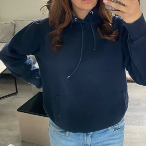 Mörkblå hoodie - Säljer en mörkblå hoodie med justerbar dragsko i huvan. 