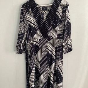 Svartvit klänning från Park Lane - Snygg svartvit klänning från Park Lane med ett geometriskt mönster av ränder och prickar. Klänningen har en v-ringning och trekvartsärmar, perfekt för en stilren look. Passar bra till både vardag och festliga tillfällen.