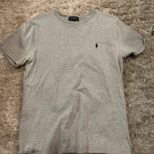 Grå t-shirt från Polo Ralph Lauren - grå tissha från ralph lauren. köpte förra sommaren alltså 2023 och hålet var så fult. passar som en lite mindre S