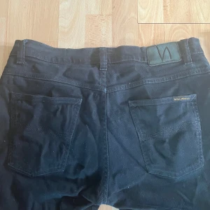 Nudie jeans svarta - Svarta jeans från märket nudie. Köpta på Plick och bara använda en gång av mig. Nudie jeans brukar vara små i waist så waist 36 som i dem här sitter som 33-34 ungefär