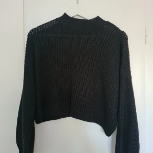 Svart stickad tröja från Forever 21 - Säljer en svart stickad tröja från Forever 21. Tröjan har en croppad design med långa ärmar och en ribbad krage. 