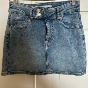 Jeanskjol - Snygg jeanskjol i klassisk blå denim med knappar framtill. Perfekt nu till sommaren! Köpt på primark, knappt använd