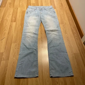 Lågmidjade bootcut jeans  - (19) De avslut perfekta ljusblåa lågmidjade bootcutjeans i storlek 29, med massa fina detaljer på fickorna. Midjemått rakt över: 35 cm, innerbenslängd: 81 cm 💜