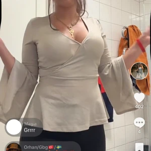 Glittring champagne blus - Väldigt snygg top från Bubbleroom, champagne färgad och glittring. Toppen har En V krage men går o lösa med säkerhetsnål. Finns en knyt man knyter bakom för och göra blusen mer tajt, har utsvängda armar. Har inga defekter som jag själv har märkt.