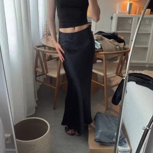 Svart långkjol i satin - Långkjol i satin. Några defekter (se bilder) 🥰