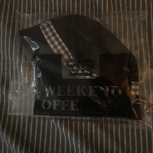 Black bucket hat  Weekend Offender - Snygg svart mössa från Weekend Offender med ett stilrent rutigt band i  blått grått och vitt. Perfekt för att hålla värmen med stil.