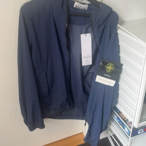 Stone island jacka - Marinblå stoneisland jacka, tunn nylon jacka som kan enkelt packas ihop, använd något år sparat alla tags. Pris kan diskuteras vid snabb affär!!!