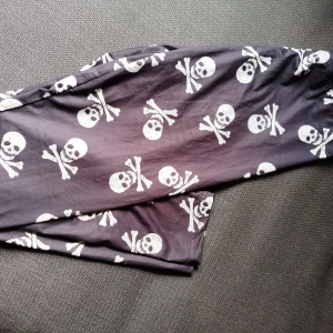 Leggings - Rockiga leggings med dödskallar i lite silkigt material. Hittar ingen storlekslapp men uppskattar att dom är en stl S. Mycket fint skick.