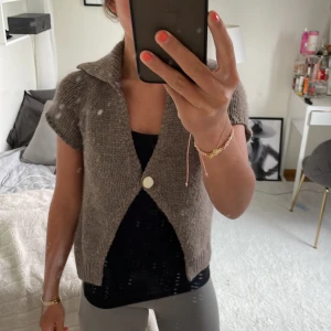 Stickad kortärmad kofta från Zara - Säljer en stickad, kortärmad kofta från Zara i en beige nyans. Koftan har en stor krage och stängs med en knapp framtill. Perfekt att slänga över en topp för en avslappnad look. Säljer denna fina koftan i jätte bra skick använt ca 4 gånger💓💓