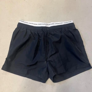 Calvin Klein svarta badshorts (nya) - svarta badbyxor med resår, dom är aldrig använda.  Storlek Large. Nypris 600kr