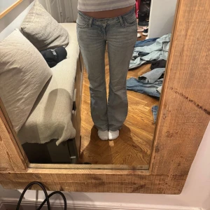 Ljusblå bootcut jeans - Säljer ett par ljusblå jeans med bootcut passform och klassisk femficksdesign. Jeansen har normal passning och är tillverkade i denim. Perfekta för dig som gillar en tidlös och avslappnad stil.