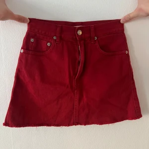 Röd jeanskjol från Brandy Melville - Säljer en röd jeanskjol med fickor och fransig kant nertill. Kjolen har knapp och dragkedja framtill samt bälteshällor. Från Brandy Melville i storlek 36, kort modell, skulle säga att den är rätt liten i storleken. Knappt använd. 