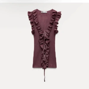 Zara topp  - Supersöt vinröd topp med djup v-ringning och volangdetaljer längs halsringningen och axlarna. Toppen är ribbad och har knyt framtill. Perfekt för att lyfta vilken outfit som helst! Aldrig använd. 