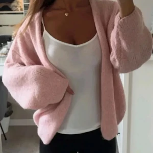 Ljusrosa stickad kofta - Mysig ljusrosa stickad kofta från lindex med lös passform och långa ärmar. Koftan är öppen framtill och har en fluffig, mjuk känsla. Perfekt att slänga över en topp för en avslappnad look.