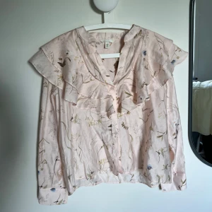 Rosa blommig blus med volang  - Säljer denna supersöta slutsålda rosa blusen från H&M. Använd två gånger. Hör av dig vid frågor!🩷