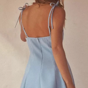Ljusblå kortklänning med knytband - Supersöt ljusblå klänning med smala axelband som knyts upptill. Klänningen har en utsvängd kjol och är perfekt för varma dagar och somriga tillfällen. Aldrig använd 🩷