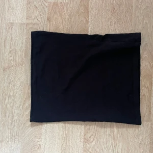 Svart tubtop - En enkel svart tubtopp i stretchigt material. Toppen har en rak passform som sitter tight runt kroppen.