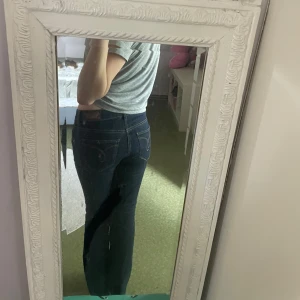 Mörkblå utsvängda jeans - Säljer ett par mörkblå jeans med utsvängda ben och klassiska fickor bak. Jeansen har låg midja och är i en modell som passar till det mesta. Perfekta i längden för dig som är 160cm och lägre. :) Storlek : W28 L 30