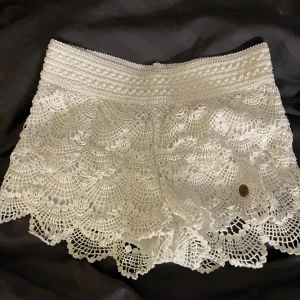 Trendiga shorts med spets! - Säljer mina jättefina vita shorts med spets detaljer. Säljer pga att dom har blivit för små, storlek är 158/168 men skulle säga att dom passar som XS. Om man inte gillar det bruna märket är det super lätt att klippa bort! Pris går att diskutera!😚
