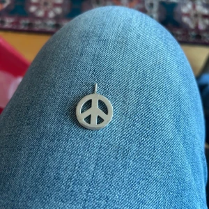 peace  hänge från Sophie by Sophie  - Säljer ett stilrent hänge i form av ett peace-märke från Sophie  by Sophie tillverkat i äkta silver (925). Perfekt att ha på en kedja som halsband. Enkel och klassisk design som passar till många stilar.