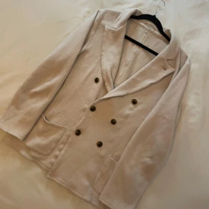 Beige merino ulls kavaj från John Henric  - Snygg stillren 100% merino wool Kavaj, med en fräsch Beige färg, storlek small köpt för några månader sen men inte kommit till användning. 