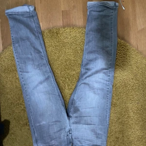 Ljusblå jeansbyxor från Replay - Säljer ett par ljusblå jeansbyxor från Replay med klassisk femficksdesign och diskret logga på bakfickan. Byxorna har en smal passform och är tillverkade i mjukt denimtyg. Perfekta för en avslappnad och stilren look.