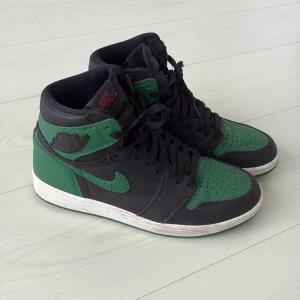 Jordan 1 high Pine Green - Äkta Jordan 1 High ”Pine Green”. Använda, se skick på bilderna. Box ingår ej*. Köpta från sneakershyllan i göteborg. Skorna fraktas i en annan skobox. 
