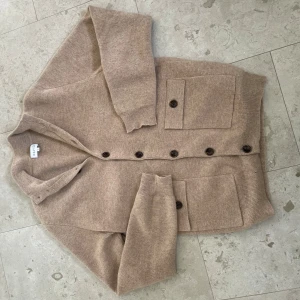 Kashmir cardigan från Davida kashmir  - Säljer en beige kofta från Davida i Kashmir . Koftan har långa ärmar, knäppning framtill med mörka knappar och två stora fickor med lock. Perfekt för lager-på-lager och enkel att matcha. Nypris hela 3400kr !!! Finns ett litet hål inget som syns vid användning kom privat för bild 