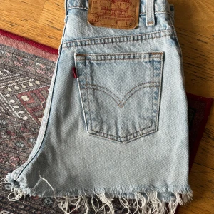 Vintage Levi’s denimshorts - Superfina vintage shorts från Levi’s. Modell enligt lapp 512, storlek enligt lapp ”S”  Uppskattar till en storlek XS. I jättefint vintage skick. Ljusa shorts med slitningar nedtill. Upplever som ganska korta. Alla fickor utan anmärkning, dragkedja fram. 