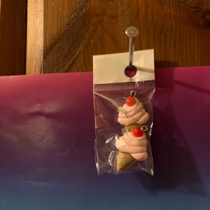 Glassörhängen med rosa och röd topping - Säljer ett par unika örhängen formade som glassar med rosa glass och röd topping. Perfekt för dig som vill sticka ut med roliga accessoarer! Kommer i förpackning.