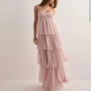 Ljusrosa långklänning med volanger - Aldrig använd, har prislapp kvar. Perfekt för somriga tillfällen eller bal.