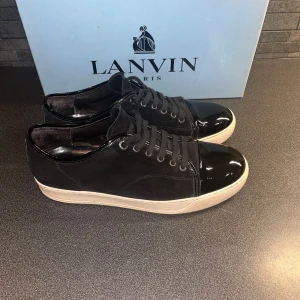 Svarta lanvins - Säljer nu ett par riktigt fräscha lanvins. Skorna är allmänt i väldigt bra skick. Skorna har inga defekter utan det lila hålet i högra hälen men det är inget man känner när man har på sig skorna. Orginal box medföljer. Boxen har dock en liten fläck men inget man tänker på. Hör gärna av er för fler frågor eller funderingar😀