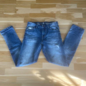 Blå jeansbyxor från LAB - Säljer ett par klassiska blå jeans från LAB med fem fickor och lätt slitna detaljer framtill.  Jeansens tvättade look ger en avslappnad stil. Jeansen är i mycket bra skick och knappt använda. Hör av dig vid fler frågor✨priset är inte hugget i sten✨
