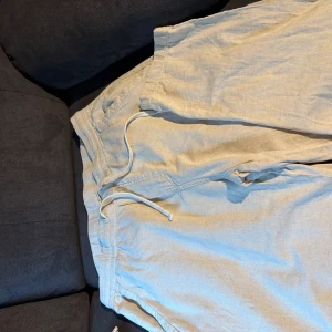 Beige linnebyxor från Zara med snörning - Säljer ett par ljusbeige linnebyxor från Zara i storlek L. Byxorna har sidofickor, perfekta för en avslappnad och luftig stil. Passformen är normal och materialet är svalt linne.