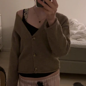 Beige kofta med knappar - Mysig beige kofta med v-ringning och tre knappar framtill. Tröjan har lång ärm och är croppad i modellen, perfekt för lager-på-lager-stil. Enkel och stilren design som passar till mycket. 💘