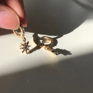 Örhängen - Guldiga stjärn-örhängen med ”kristaller” på, från Glitter. Använda 1 gång.